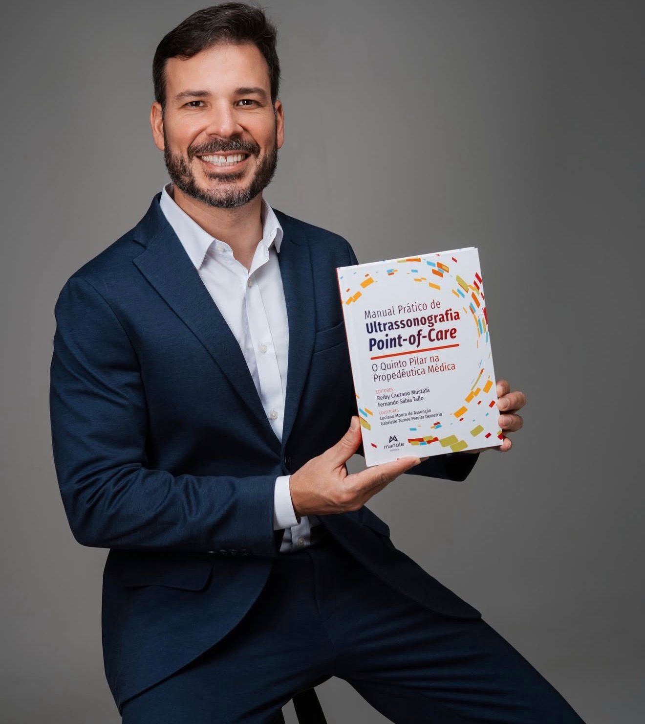 Dr. Reiby Caetano Mustafá segurando seu livro